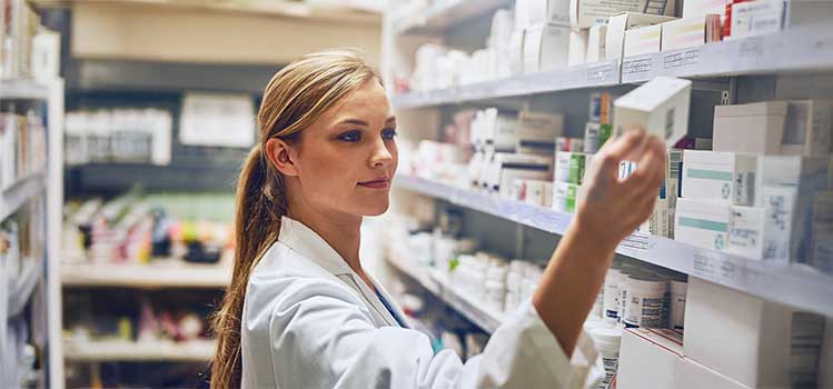 pharmacy technician stocks inventory on pharmacy shelves
