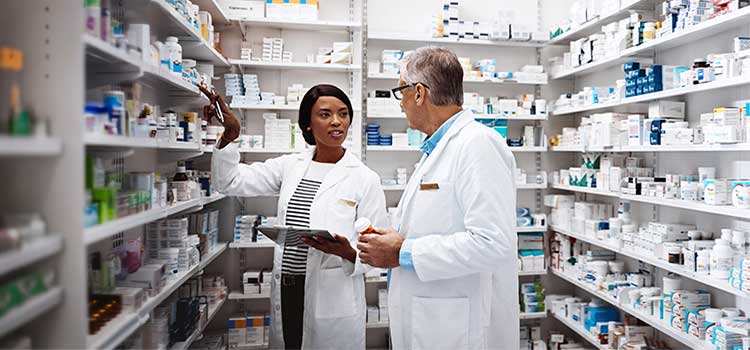 pharmacy technician discusses pharmaceutical inventory with pharmacist